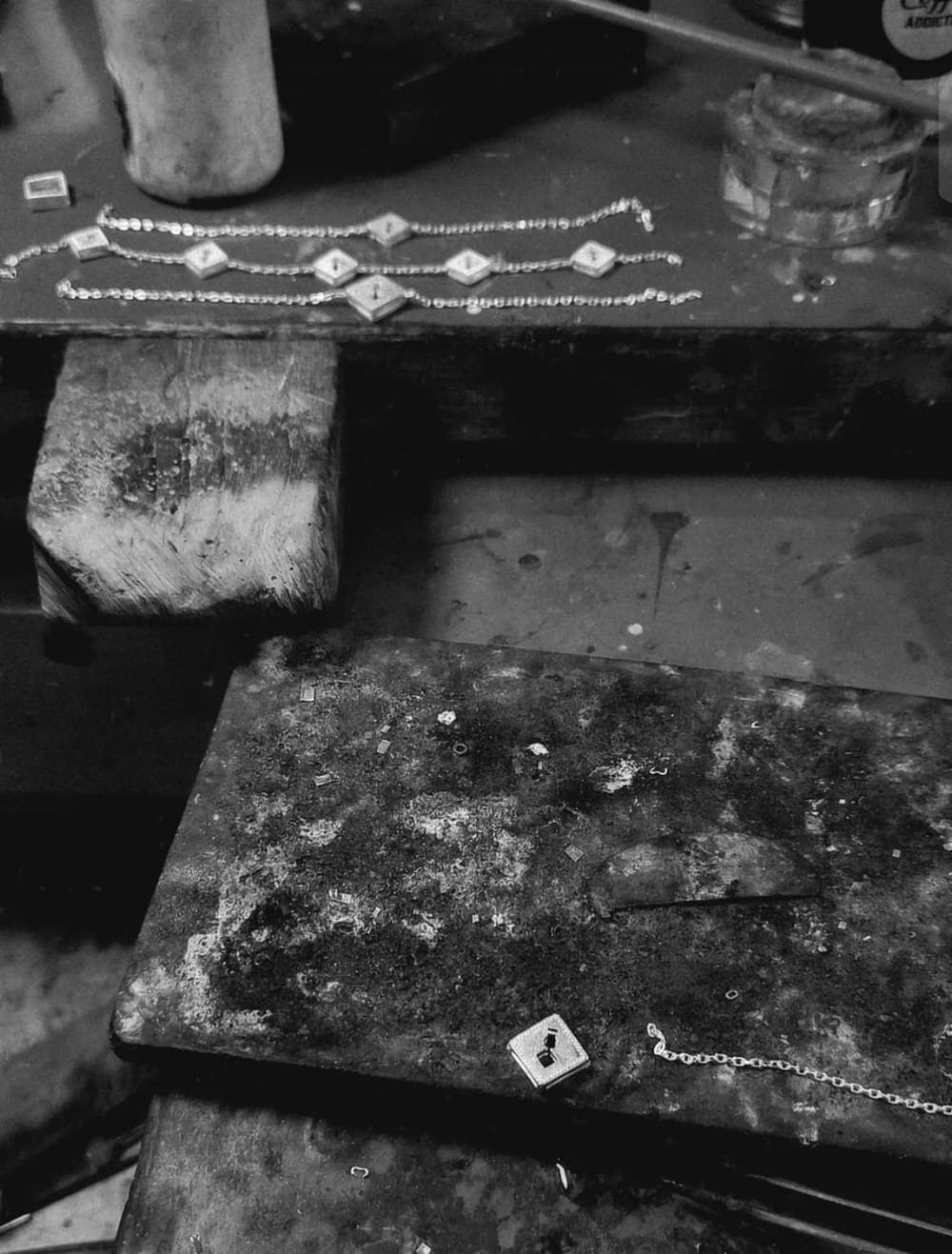 Chains and pendants laid out on the workshop bench