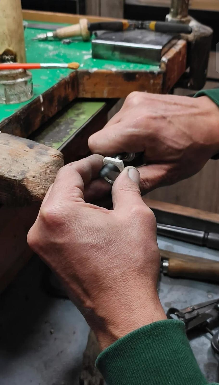 Hands shaping a silver ring at the SOLAX workbench